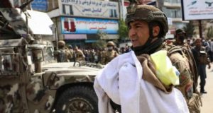 An Afghan soldier cradles a baby in his arms after the attack in Kabul