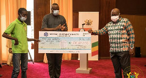 Nana Addo Dankwa Akufo-Addo presenting a cheque to a beneficiary