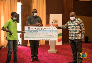 Nana Addo Dankwa Akufo-Addo presenting a cheque to a beneficiary